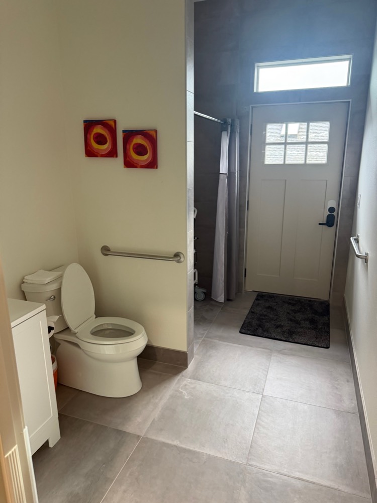 An accessible bathroom with grab bars and a roll-in shower